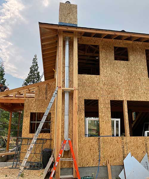 Newly contructed home just in the framing stage with external chimney showing