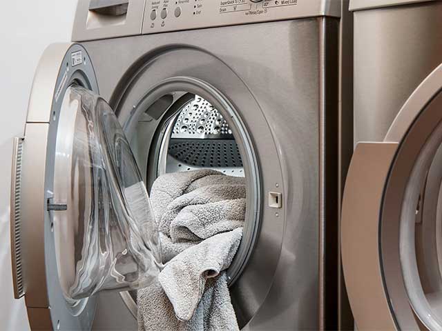 Steel Colored Clothes Dryer with door open and bath towels hanging out