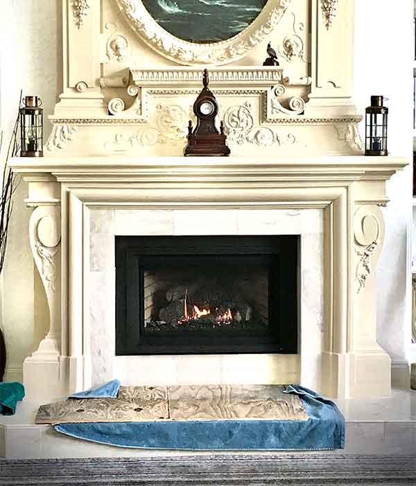 gas fireplace insert in large white heart fireplace clock resting on mantle and rug in front of fire