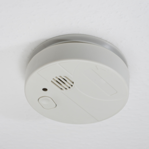 a white smoke detector on a white ceiling