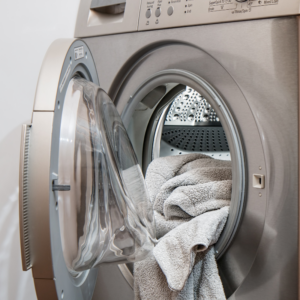 an open dryer with clothes partially hanging out