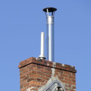 a long metal chimney liner coming out of a masonry chimney