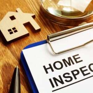 home inspection report next to a small wooden house and a pen
